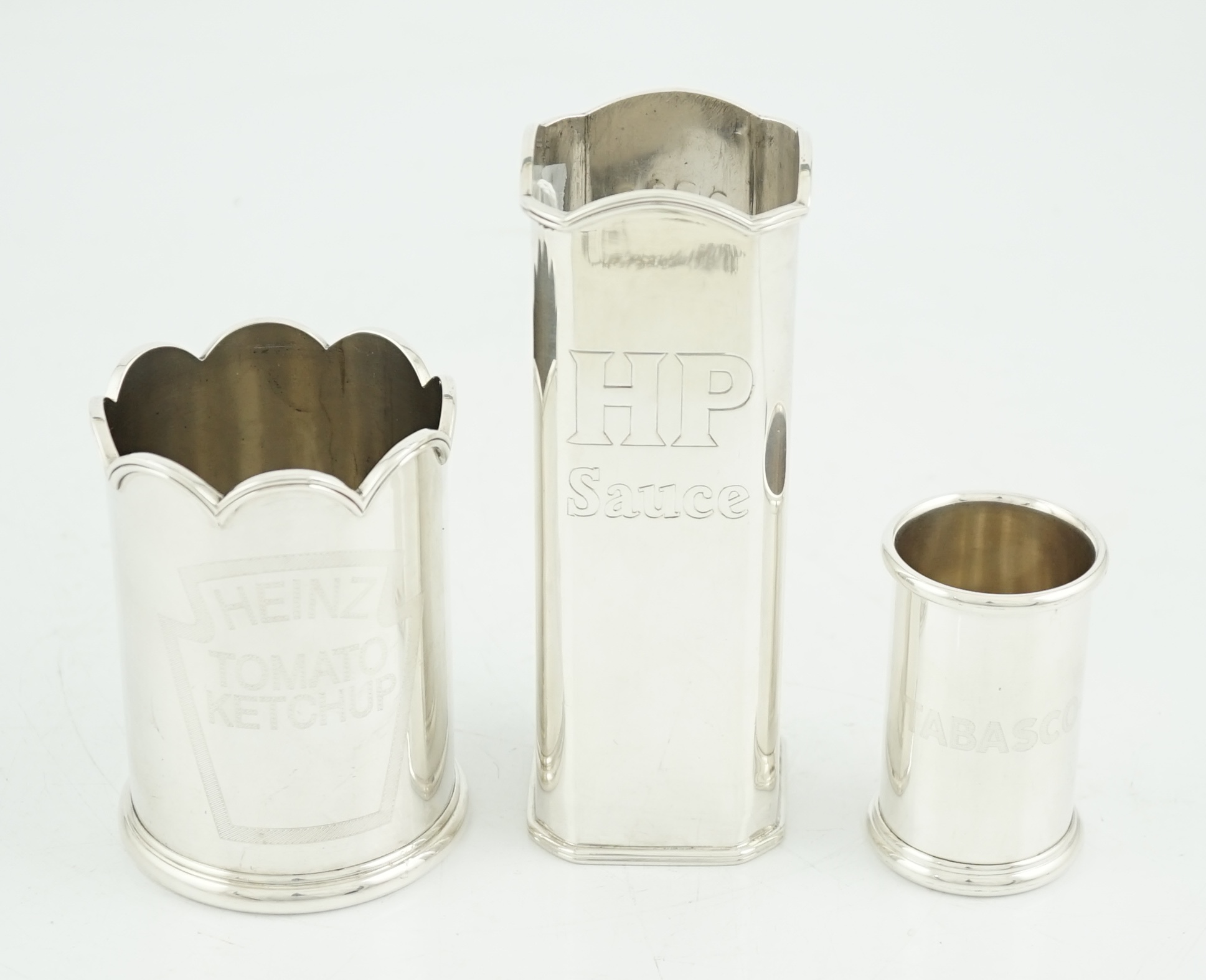 Three assorted Elizabeth II Theo Fennell silver bottle holders